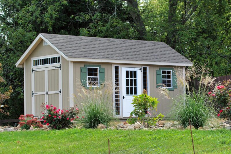 One of our Cape Cod sheds for sale in Dublin OH - Beige siding with white-trimmed windows with green shutters - single and double doors - gray roof