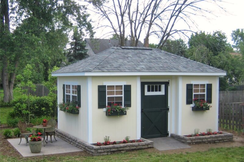 One of our custom sheds for sale in Dublin OH - Pale yellow siding - black doors and shutters - white-frammed windows - gray roof