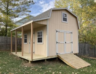 One of our peach retreat sheds For Sale in Dublin OH - peach siding with wooden porch and gray roof - fenced backyard with fallen tree leaves
