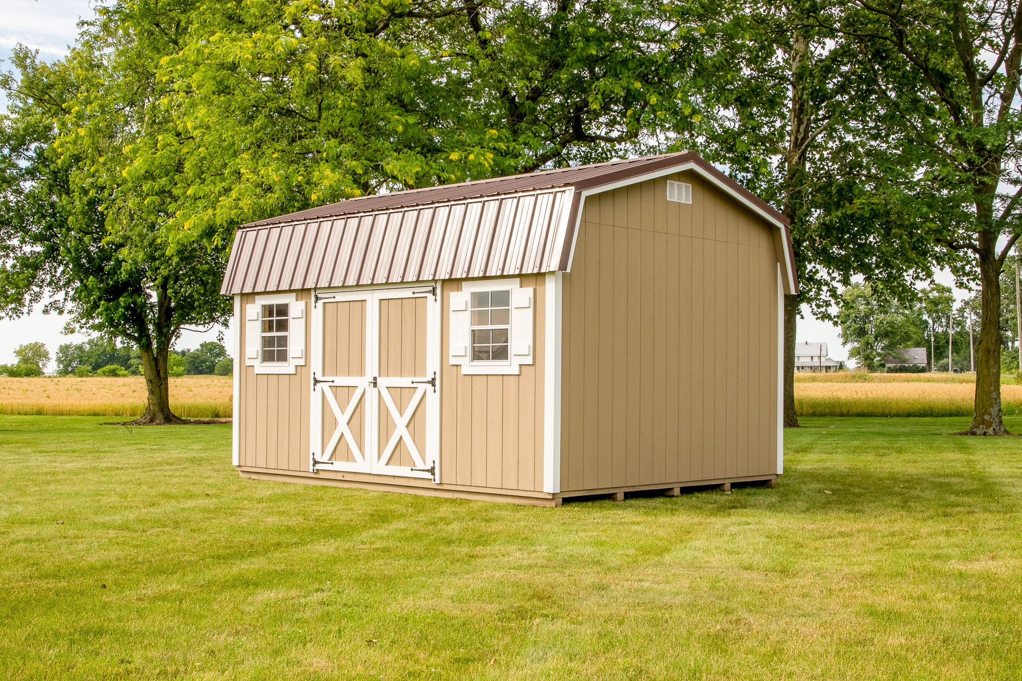Tan highwall barn shed with brown metal roof and white trim.