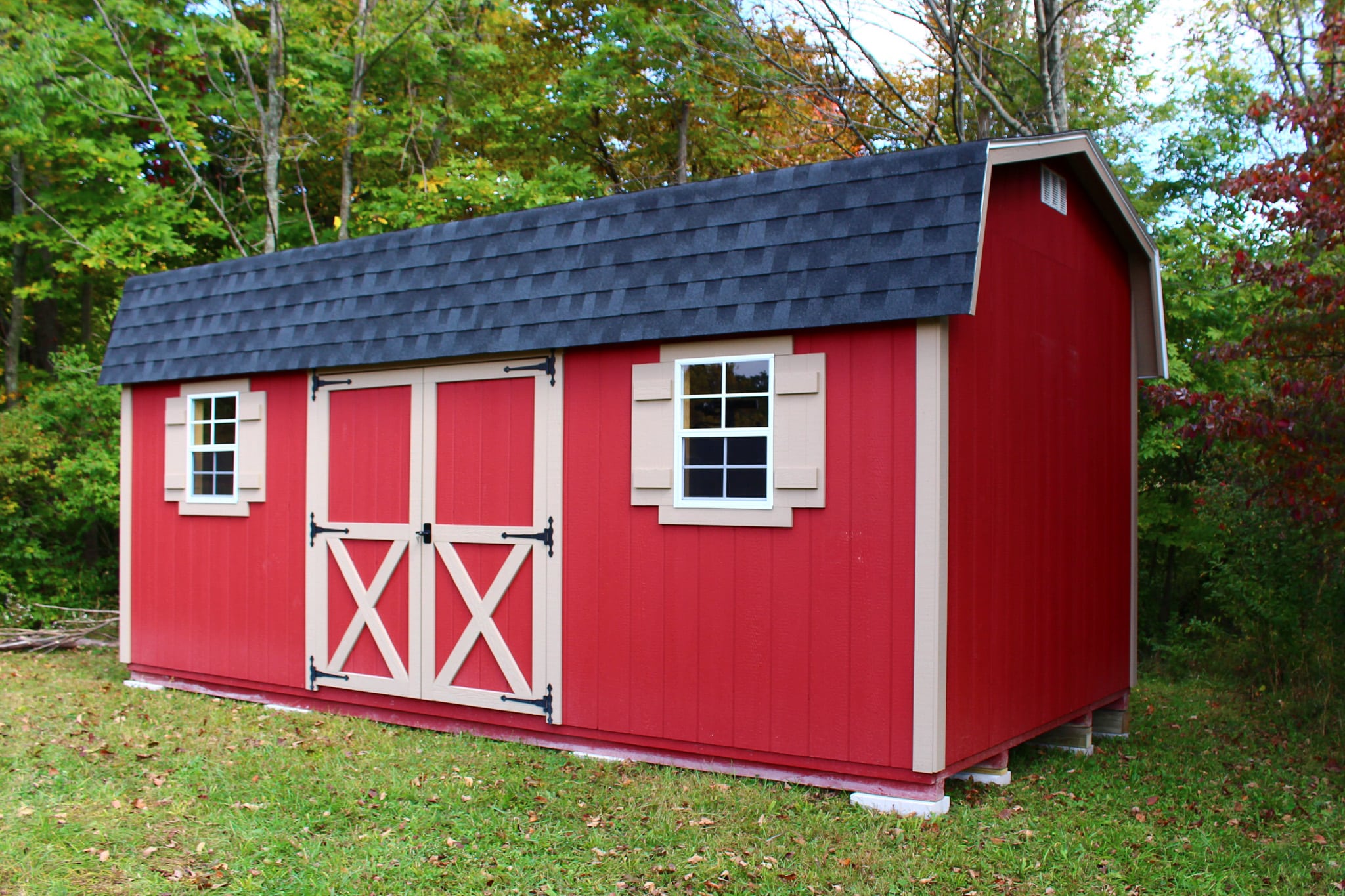 a red side barn shed with white trim and a dark shingle roof in Ohio
